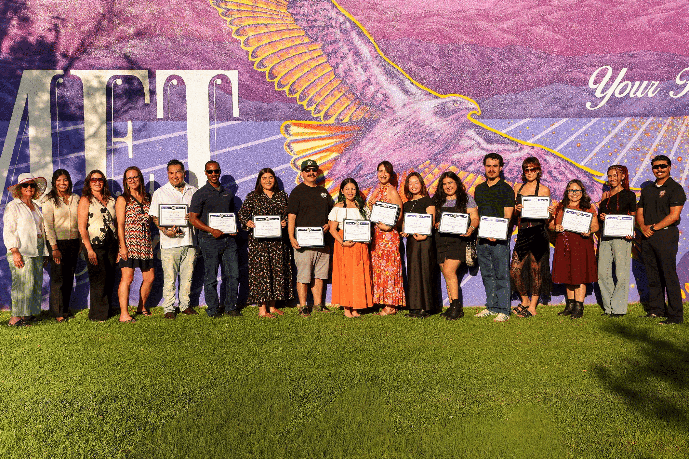 community standing in front of finished mural